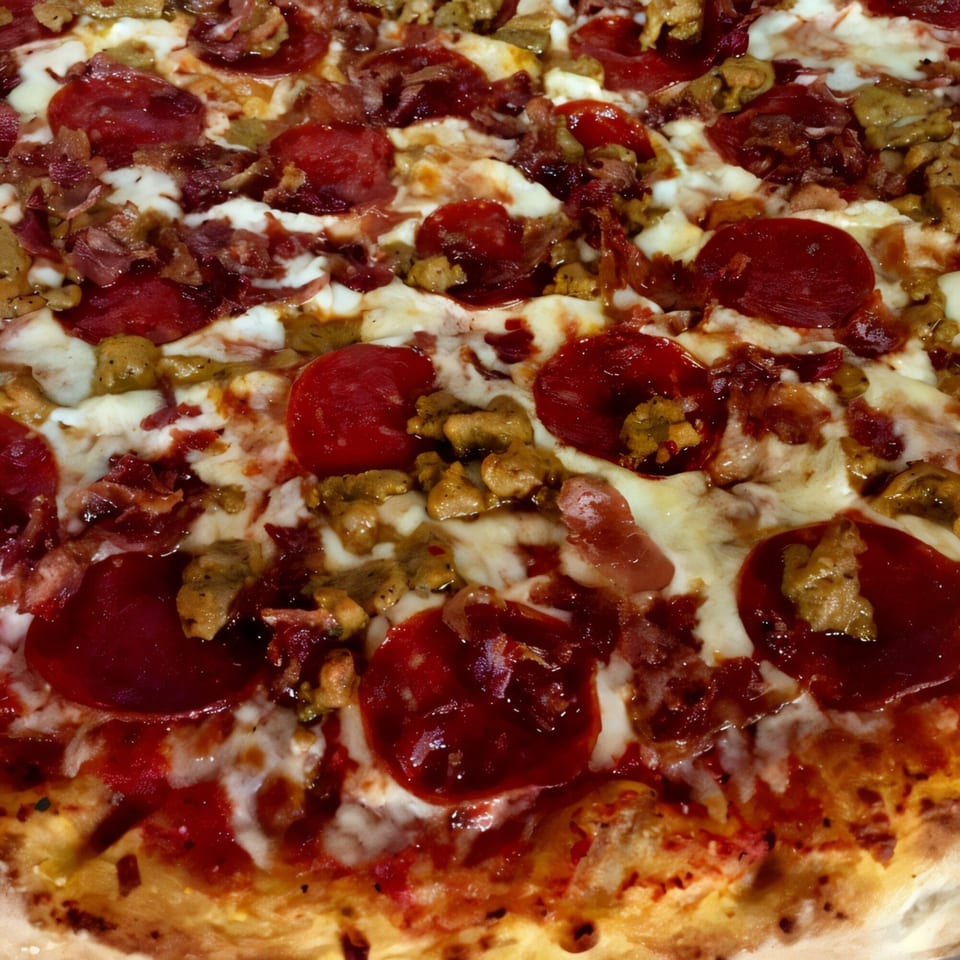 Close-up of a meat lover's pizza from Italian Village Pizza, topped with pepperoni, sausage, and bacon.